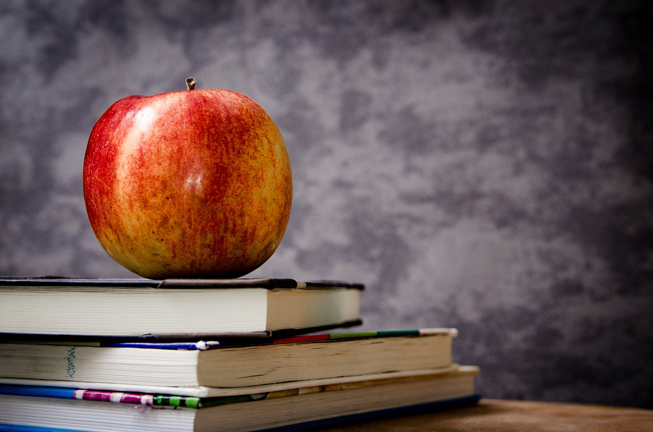 apple, textbooks, and chalkboard in a classroom